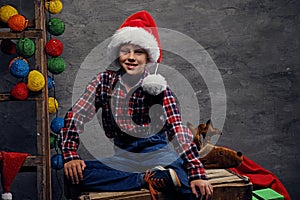 Portrait of teenage boy dressed in Santa`s hat and a plaid shirt.