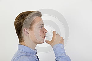 Teenage boy drinking water out of a glass