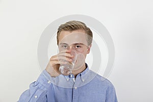 Teenage boy drinking water out of a glass