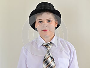 portrait of a teenage boy in hat and tie photo