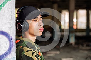 Portrait of teenage boy with headphones and black cap on head