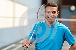 portrait teenage boy holding badminton racket