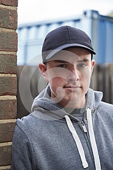 Portrait Of Teenage Boy Leaning Against Wall In Urban Setting