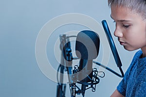 Portrait of teenage boy wearing headphones using microphone