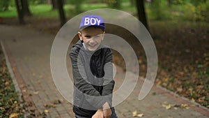 Portrait of a teenage boy who dances on a pennyboard. A guy of European appearance is having fun dancing and smiling