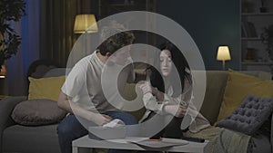 Portrait of teenage couple spending time. Girl reading something bad on smartphone, looks very sad, boy comes in and