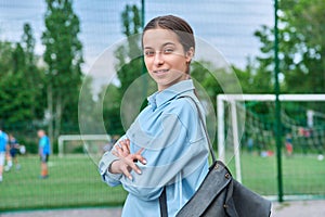 Portrait of teenage female student looking at camera, school stadium background