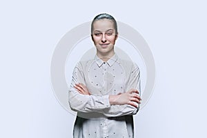 Portrait of teenage girl with crossed arms on white background