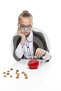 Portrait of Teenage Girl in Dark Jacket Putting Coin Into The Piggybank For Savings