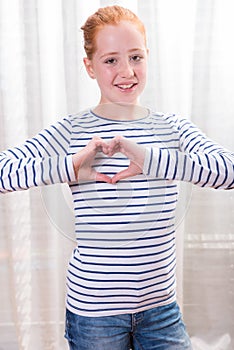 Portrait teenage girl forming heart shape with hands