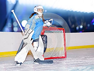 Girl goaltender next to the net at hockey stadium photo