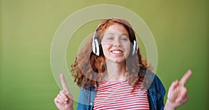 Portrait of teenage girl in headphones enjoying music and dancing