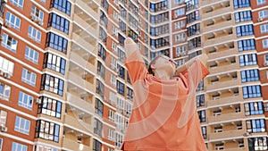 Portrait of a teenage girl with her arms outstretched enjoying a new place of residence against the backdrop of high