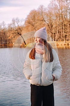 Portrait teenage girl looking away wearing casual fall clothes in an autumn park with lake outdoors