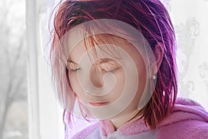 Portrait of teenage girl with red hair. Lady lowers her eyes and looks down. Sad emotions on face. Close-up, selective focus