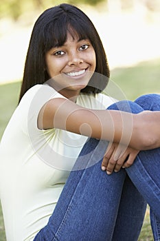 Portrait Of Teenage Girl Sitting In Park