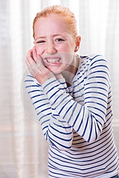 Portrait teenage girl with tooth ache