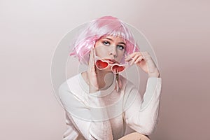 Portrait of teenage model with pink hair posing against pastel background