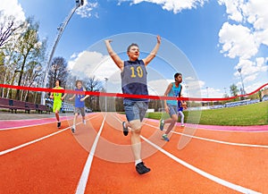 Portrait of teenage sprinter crossing finish line