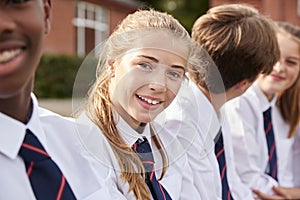 Portrait Of Teenage Students In Uniform Outside School Buildings