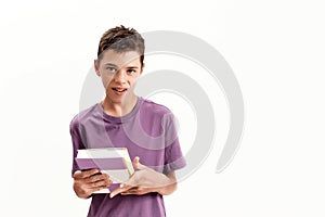 Portrait of teenaged disabled boy with cerebral palsy looking at camera and holding a book, posing isolated over white