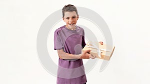 Portrait of teenaged disabled boy with cerebral palsy smiling while holding a gift box, present standing isolated over