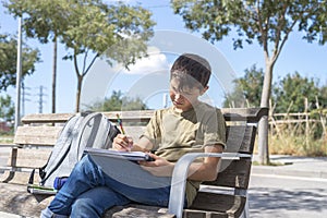 Portrait of a teenager boy sitting doing his homework