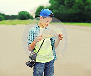 Portrait of teenager boy tourist sightseeing city with paper map