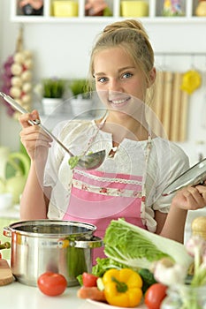 Portrait of teenager girl coocking soup on kitchen