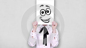 Portrait, teenager holds white paper sheet with happy smiley drawing, animation, covering face. emotions, Imagination