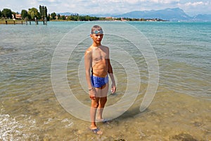 Portrait of a teenager in swimming trunks on the beach.