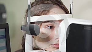 Portrait of teenager who undergoes the procedure of an ophthalmoscopy in clinic