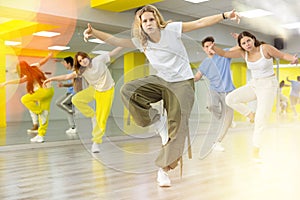 Portrait of teens dancer in choreographic studio with dancing teenagers in background