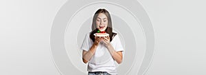 Portrait of tempted beautiful girl licking lips as looking at cake