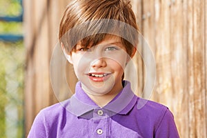 Portrait of ten years old boy in purple polo shirt