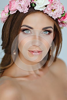 Portrait of a tender beautiful girl in a pink dress and a wreath