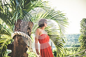 Portrait of tender woman near the palm on the tropical island Nusa Lembongan, Bali, Indonesia.