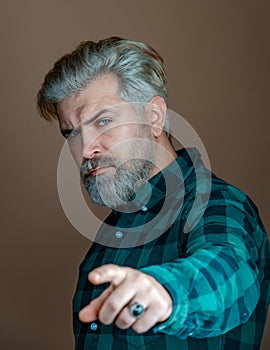 Portrait of thinking stylish young man. Handsome man with a beard. Portrait of businessman  on grey background.