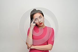 Portrait of thinking woman holding fingers on temples looking up having frustrated look trying to remember something important