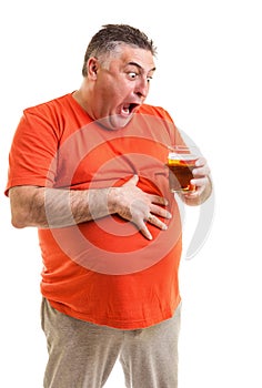 Portrait of a thirsty fat man staring at a glass of beer