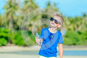 Portrait of a thirsty handsome boy in sunglasses drinking water