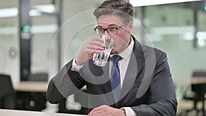 Portrait of Thirsty Middle Aged Businessman Drinking Water