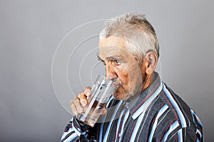 Portrait of a thirsty senior man drinking water