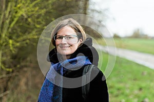 Portrait of a thirty year old beautiful woman with glasses at the Belgian countryside