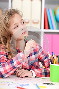 Portrait of thoughtful little girl drawing at her room