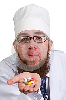 Thoughtful male doctor holding a pill on white background