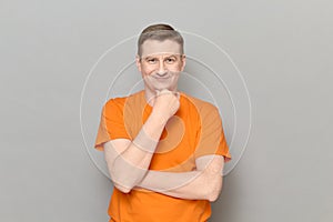 Portrait of thoughtful man touching chin with hand and smiling