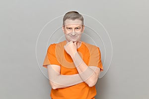 Portrait of thoughtful man touching chin with hand and smiling