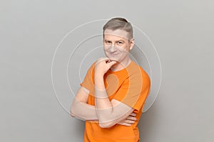 Portrait of thoughtful man touching chin with hand and smiling