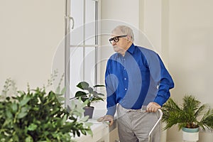 Portrait of thoughtful senior man looking through window